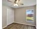 This cozy bedroom features a ceiling fan, wood-look flooring, a closet, and a window for natural light at 2019 Wintermere Pointe Dr, Winter Garden, FL 34787