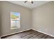 Bright bedroom with wood-look flooring, a window, neutral walls and a ceiling fan at 2019 Wintermere Pointe Dr, Winter Garden, FL 34787