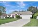 Inviting one-story home featuring a two-car garage, landscaped lawn, and red trim accents at 2019 Wintermere Pointe Dr, Winter Garden, FL 34787