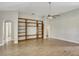 Living room featuring hardwood floors, neutral walls, wooden bookcase, and ceiling fan at 2019 Wintermere Pointe Dr, Winter Garden, FL 34787