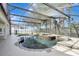 Screened-in pool with rock waterfall feature surrounded by lush landscaping and privacy fence at 2019 Wintermere Pointe Dr, Winter Garden, FL 34787