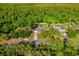 Bird's eye view of the home featuring mature trees surrounding a well manicured lawn and long driveway at 2049 Eldorado Ct, St Cloud, FL 34771