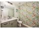 Floral powder room featuring a vanity with a sink and a patterned accent wall at 2049 Eldorado Ct, St Cloud, FL 34771