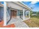 Inviting front porch featuring a beautiful wood door, stylish stone accents, and a cozy seating area at 2049 Eldorado Ct, St Cloud, FL 34771