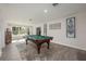 Spacious game room featuring a billiard table and decorative area rug beneath the bright window at 2049 Eldorado Ct, St Cloud, FL 34771