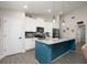 Modern kitchen featuring white cabinets, stainless steel appliances, a large island, and stylish pendant lighting at 2049 Eldorado Ct, St Cloud, FL 34771