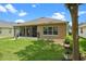 Backyard with grassy lawn, and a screened-in porch, providing a tranquil outdoor space at 2217 Caledonian St, Clermont, FL 34711