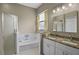 Bathroom with double sink vanity, granite counters, shower, tub, and neutral tones at 2217 Caledonian St, Clermont, FL 34711