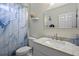 Bright bathroom featuring marble countertop, a framed mirror, and a blue patterned shower curtain at 2217 Caledonian St, Clermont, FL 34711