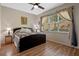 Bedroom featuring a bed with a decorative quilt, wood floors, and a large window with lush views at 2217 Caledonian St, Clermont, FL 34711