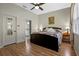 Bedroom featuring a bed with a decorative quilt, wood floors, and a door to the bathroom at 2217 Caledonian St, Clermont, FL 34711