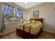 Bedroom with blue and yellow decor, window view, and wood floors at 2217 Caledonian St, Clermont, FL 34711