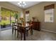 Dining room with wood table, chandelier, and access to outdoor patio with lots of natural light at 2217 Caledonian St, Clermont, FL 34711