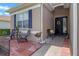 Inviting home entrance with brick patio, seating, and a black front door adorned with a yellow wreath at 2217 Caledonian St, Clermont, FL 34711
