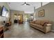 Spacious living room with tile floors, a ceiling fan, a comfortable couch, and sliding glass doors at 2217 Caledonian St, Clermont, FL 34711