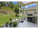 Screened patio with outdoor grill and view of a lush backyard and beautiful landscaping at 2217 Caledonian St, Clermont, FL 34711
