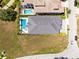 Aerial view of property with swimming pool and luxurious landscaping near a neighborhood street at 300 Muirfield Loop, Reunion, FL 34747