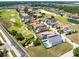Aerial view of a residential neighborhood with well-maintained homes, lush green golf course and scenic ponds at 300 Muirfield Loop, Reunion, FL 34747