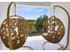 Relax on the balcony with hanging wicker chairs and enjoy the scenic views of the lush landscaping at 300 Muirfield Loop, Reunion, FL 34747
