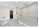 Contemporary bathroom features soaking tub, large glass shower, and modern fixtures at 300 Muirfield Loop, Reunion, FL 34747