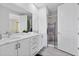 Bright bathroom features a double vanity, modern shower with glass door, and light gray wood-look floors at 300 Muirfield Loop, Reunion, FL 34747