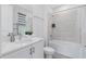 Modern bathroom with a combination shower and bathtub with tiled walls, a white vanity, and a decorative plant at 300 Muirfield Loop, Reunion, FL 34747