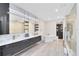 Stylish bathroom with modern fixtures, soaking tub, marble counters, and a large shower at 300 Muirfield Loop, Reunion, FL 34747