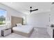 A bright bedroom is adorned with a neutral color scheme, plush rug, large windows, and modern furnishings at 300 Muirfield Loop, Reunion, FL 34747
