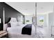 Primary bedroom features modern bed, accent wall, and natural light at 300 Muirfield Loop, Reunion, FL 34747