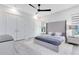 Bright bedroom with a grey tufted headboard, ceiling fan, and and closets at 300 Muirfield Loop, Reunion, FL 34747