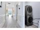 Hallway with decorative molding along the walls and a stacked washer and dryer unit at 300 Muirfield Loop, Reunion, FL 34747