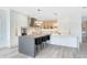 Modern kitchen with pendant lights, an island with bar seating, and stainless steel appliances at 300 Muirfield Loop, Reunion, FL 34747