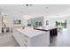Bright open-concept kitchen with quartz countertops, stainless steel appliances, pendant lighting and an attached living and dining area at 300 Muirfield Loop, Reunion, FL 34747