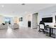 Modern living room with entertainment area and separate office/den space with laundry at 300 Muirfield Loop, Reunion, FL 34747