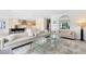 Bright, open living room showcasing elegant sofas, glass coffee tables, and seamless flow into the modern kitchen at 300 Muirfield Loop, Reunion, FL 34747