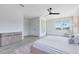 Bright main bedroom featuring hardwood floors, ambient lighting, three windows, and a black ceiling fan at 300 Muirfield Loop, Reunion, FL 34747