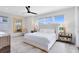 Bright main bedroom with hardwood floors, a large mirror, and a tufted headboard, accentuated by natural light from large windows at 300 Muirfield Loop, Reunion, FL 34747