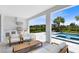 Covered outdoor living space with summer kitchen, seating, and views of the pool and lush landscaping at 300 Muirfield Loop, Reunion, FL 34747