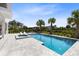 Inviting pool area with a sun-soaked deck, lounge chairs, and tropical landscaping, creating a private oasis at 300 Muirfield Loop, Reunion, FL 34747