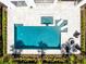 Aerial view of a private backyard pool and spa surrounded by a paver deck, lounge chairs, and manicured landscaping at 300 Muirfield Loop, Reunion, FL 34747