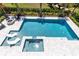 Aerial view of a private pool with in-pool loungers, attached spa, and spacious patio perfect for entertaining at 300 Muirfield Loop, Reunion, FL 34747