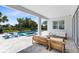 Covered outdoor seating area with a view of the pool and spa, surrounded by lush greenery at 300 Muirfield Loop, Reunion, FL 34747
