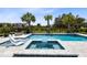 Beautiful backyard pool with in-ground jacuzzi, lounge chairs, fire pit, and lovely landscaping at 300 Muirfield Loop, Reunion, FL 34747