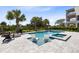 Sparkling pool with built-in lounge chairs and a spa, surrounded by a brick patio and manicured landscaping at 300 Muirfield Loop, Reunion, FL 34747