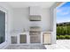 Outdoor kitchen boasts a stainless steel grill, sink, and refrigerator, perfect for entertaining by the pool at 300 Muirfield Loop, Reunion, FL 34747