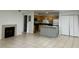 Bright living room with tile flooring, fireplace, and an adjacent kitchen area with an island and stainless steel appliances at 315 Lakepointe Dr # 101, Altamonte Springs, FL 32701