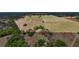 Expansive aerial view of fenced acreage featuring lush pastures, mature trees, and a long driveway leading to a home at 35651 Huff Rd, Eustis, FL 32736