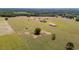 Aerial view showcasing a ranch-style home, a barn and fully fenced pastures, providing ample space and privacy at 35651 Huff Rd, Eustis, FL 32736