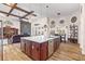 Spacious kitchen island with bar seating and open layout to the living room with stone fireplace and wood beam ceiling at 35651 Huff Rd, Eustis, FL 32736
