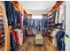 Spacious walk-in closet with custom shelving, wooden floors, and a cushioned bench for comfortable dressing at 35651 Huff Rd, Eustis, FL 32736